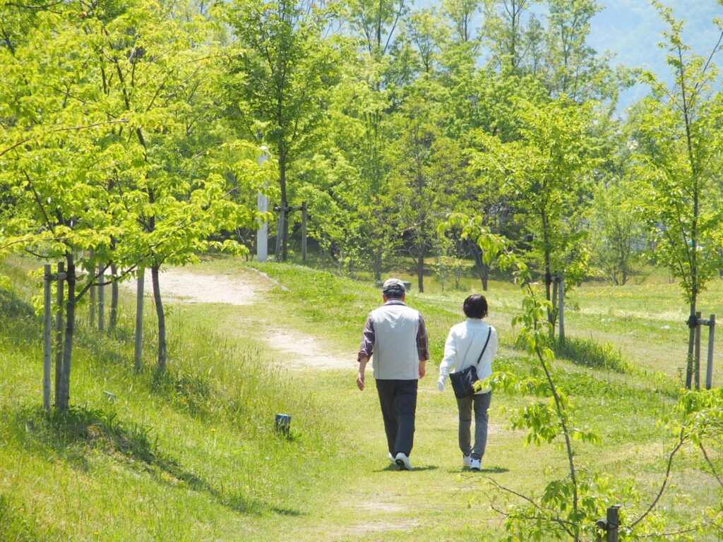 50代からの穏やかな暮らしをイメージした夫婦の散歩風景